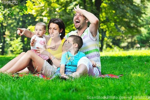 Image of happy young couple with their children have fun at park