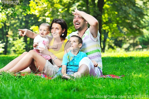 Image of happy young couple with their children have fun at park