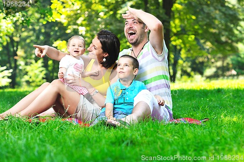 Image of happy young couple with their children have fun at park