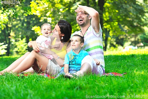 Image of happy young couple with their children have fun at park