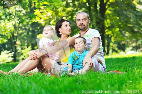 Image of happy young couple with their children have fun at park