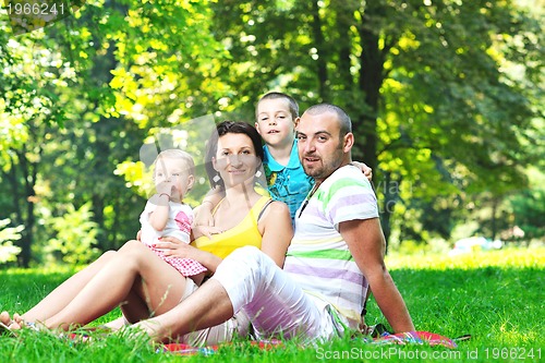 Image of happy young couple with their children have fun at park
