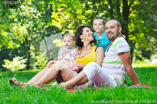Image of happy young couple with their children have fun at park