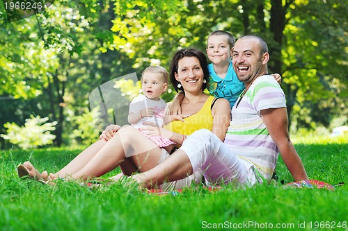 Image of happy young couple with their children have fun at park