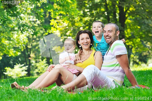 Image of happy young couple with their children have fun at park