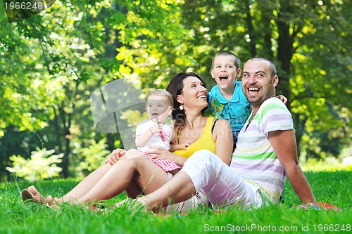 Image of happy young couple with their children have fun at park