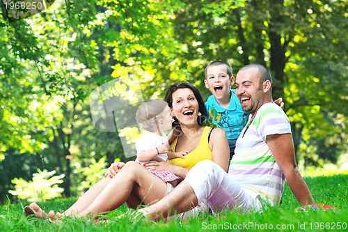 Image of happy young couple with their children have fun at park