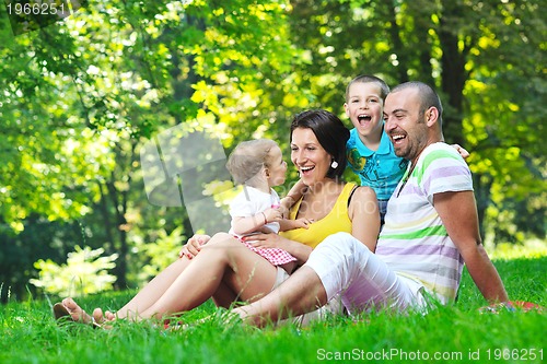Image of happy young couple with their children have fun at park