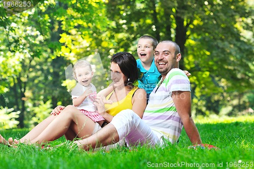 Image of happy young couple with their children have fun at park