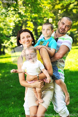 Image of happy young couple with their children have fun at park