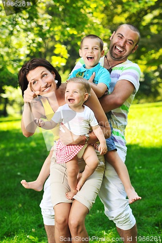 Image of happy young couple with their children have fun at park