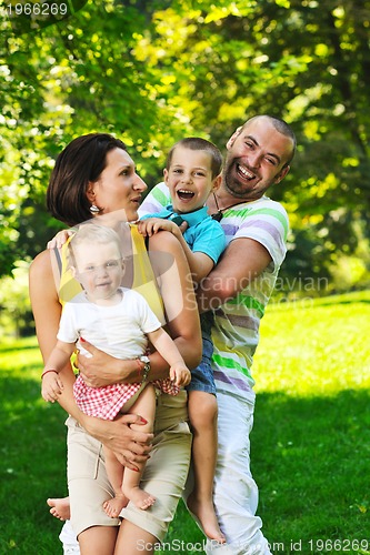 Image of happy young couple with their children have fun at park