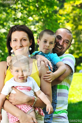 Image of happy young couple with their children have fun at park