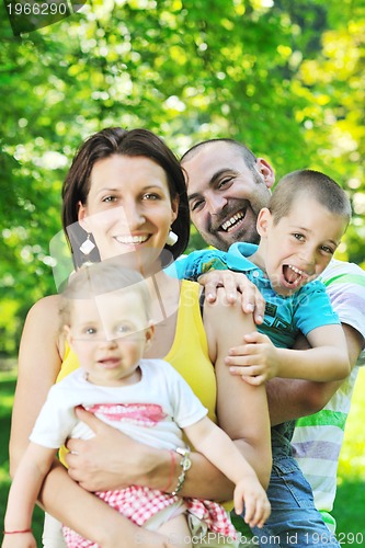 Image of happy young couple with their children have fun at park