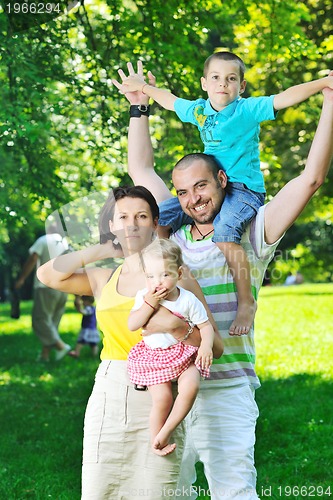Image of happy young couple with their children have fun at park