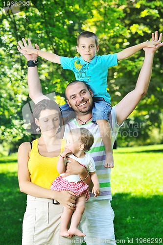 Image of happy young couple with their children have fun at park