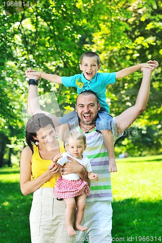 Image of happy young couple with their children have fun at park