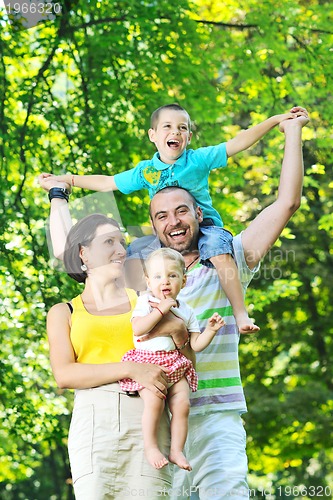 Image of happy young couple with their children have fun at park
