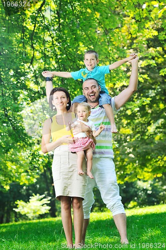 Image of happy young couple with their children have fun at park