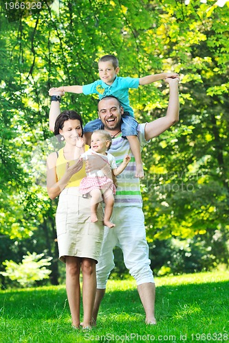 Image of happy young couple with their children have fun at park