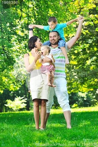 Image of happy young couple with their children have fun at park