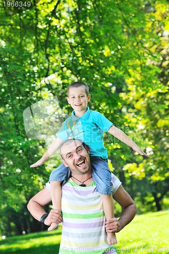 Image of happy father and son have fun at park