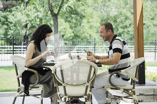 Image of happy young couple eat at restaurant
