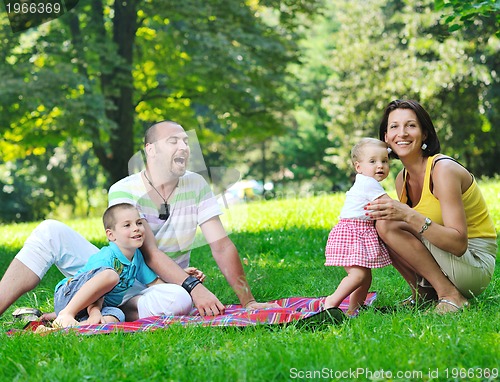 Image of happy young couple with their children have fun at park