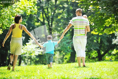 Image of happy young couple with their children have fun at park