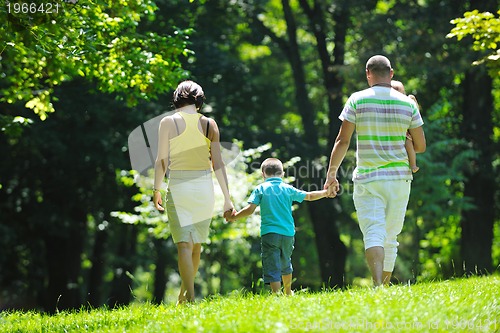 Image of happy young couple with their children have fun at park