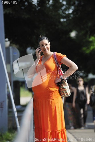 Image of happy pregnant woman talking by cellphone