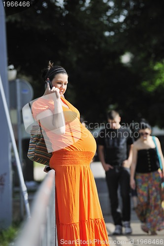 Image of happy pregnant woman talking by cellphone