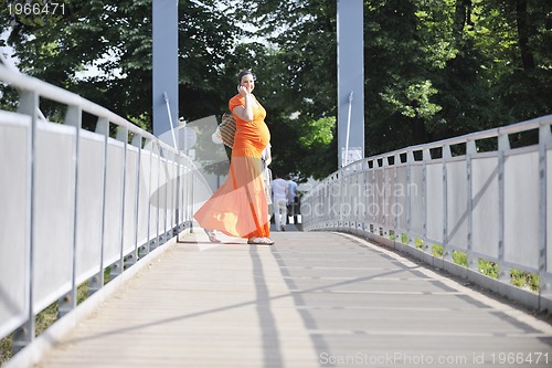 Image of happy pregnant woman talking by cellphone