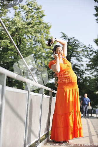 Image of happy pregnant woman talking by cellphone