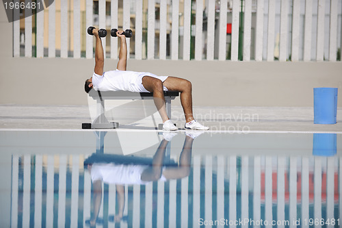 Image of young man exercise at poolside