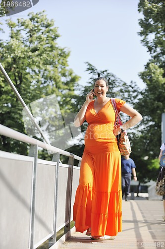 Image of happy pregnant woman talking by cellphone