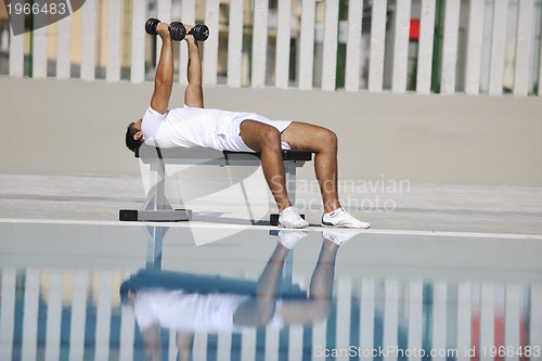 Image of young man exercise at poolside
