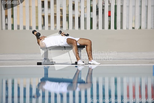 Image of young man exercise at poolside
