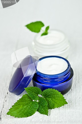 Image of face cream in jars with urtica leaves