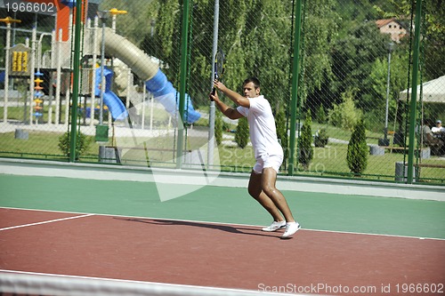 Image of young man play tennis outdoor