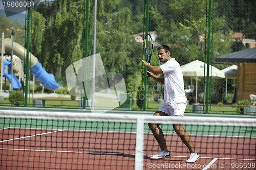 Image of young man play tennis outdoor