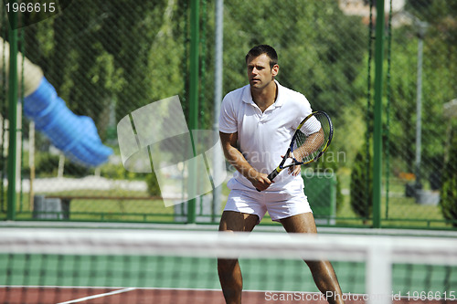 Image of young man play tennis outdoor