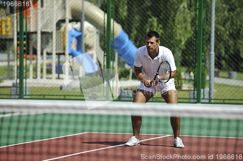 Image of young man play tennis outdoor