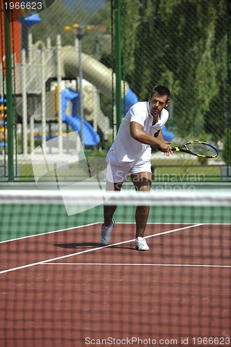 Image of young man play tennis outdoor