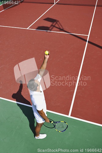 Image of young man play tennis outdoor