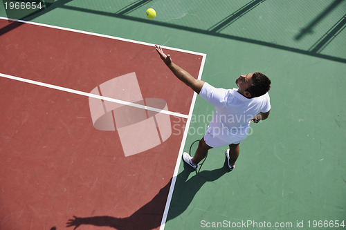 Image of young man play tennis outdoor