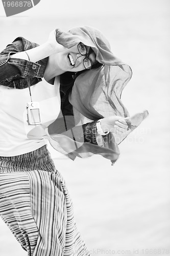 Image of beautiful young woman on beach with scarf