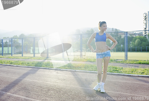 Image of happy young woman on athletic race track