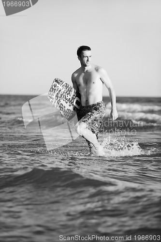 Image of Portrait of a young  kitsurf  man at beach on sunset