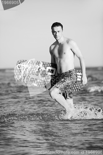 Image of Portrait of a young  kitsurf  man at beach on sunset